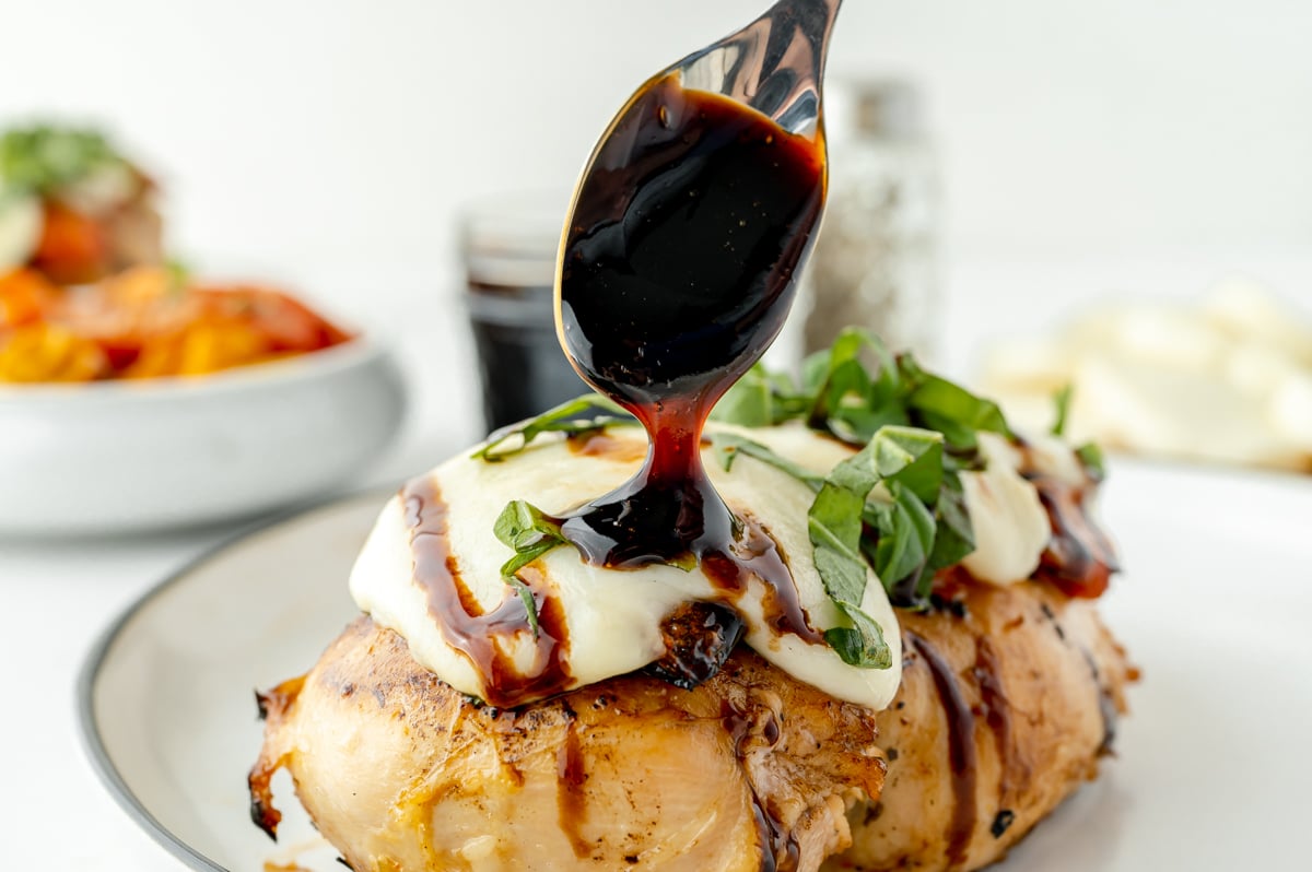 balsamic glaze spooned onto caprese chicken