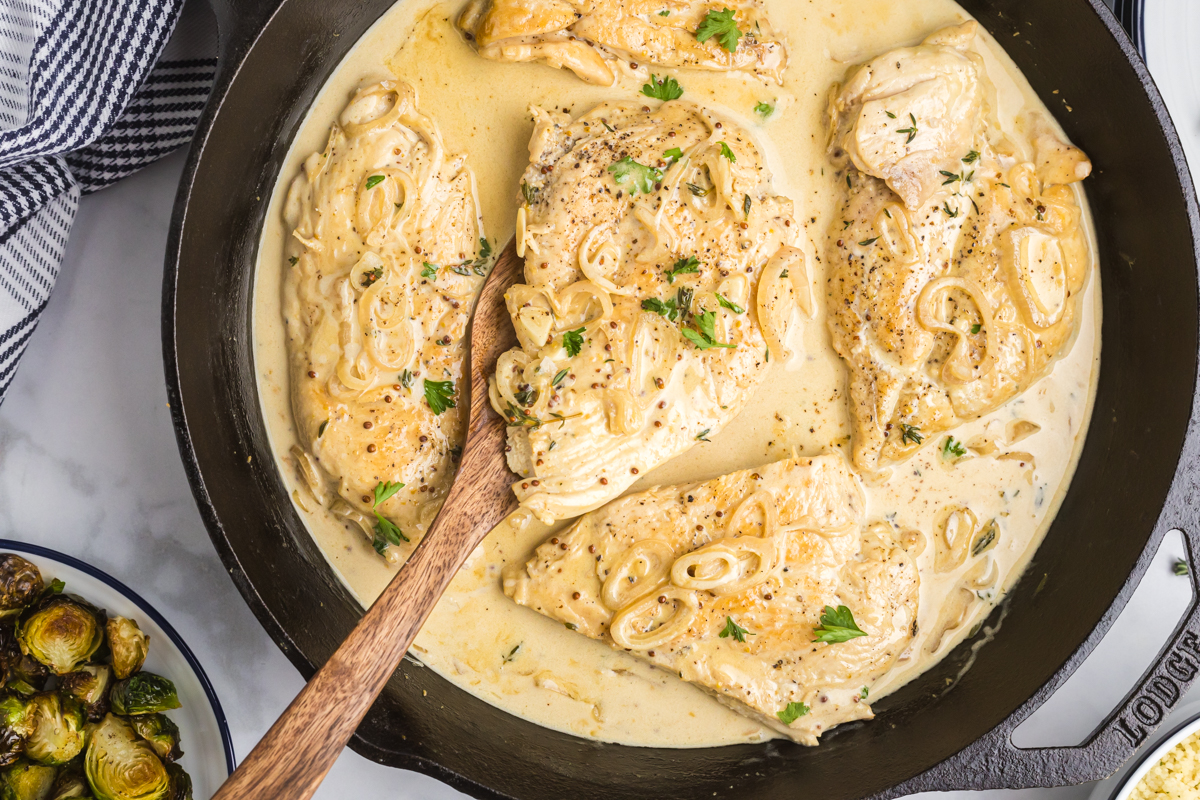 overhead shot of spatula in pan of dijon chicken