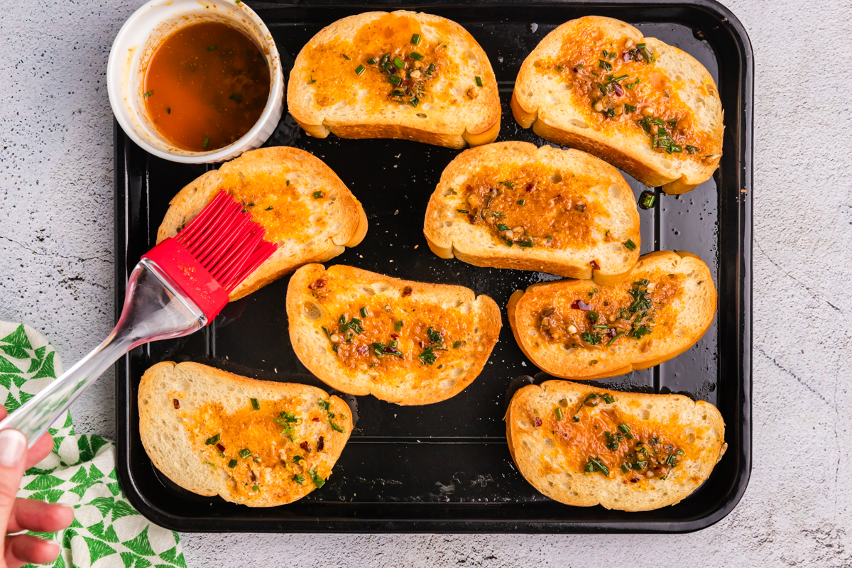 overhead shot of melted cowboy butter brushed onto bread slices