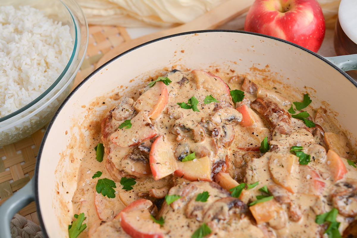 close up angled shot of creamy apple pork chops in pan