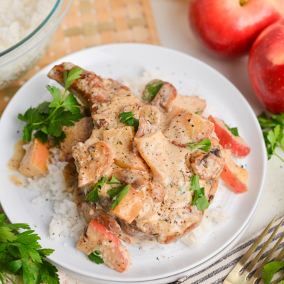 angled shot of creamy apple pork chops over rice