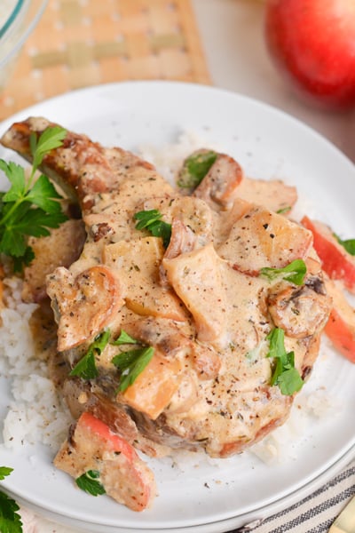 angled shot of creamy apple pork chops over rice