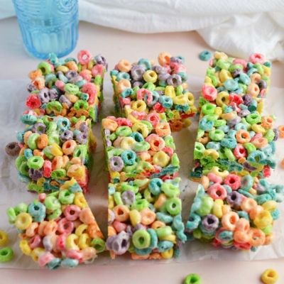 angled shot of fruit loop cereal bars cut on parchment paper