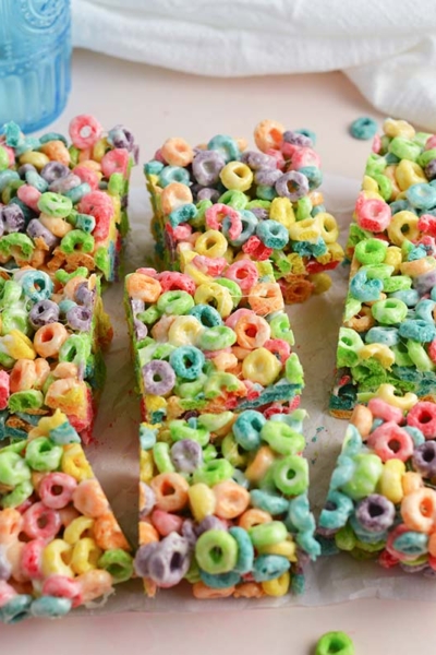 angled shot of fruit loop cereal bars cut on parchment paper