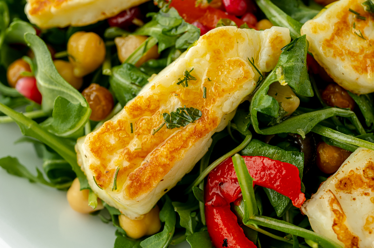 close up overhead shot of fried halloumi on salad