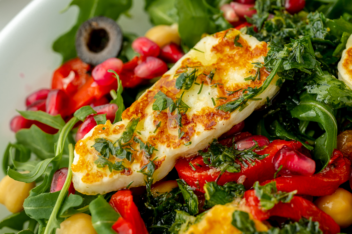 angled shot of fried halloumi on salad with dressing