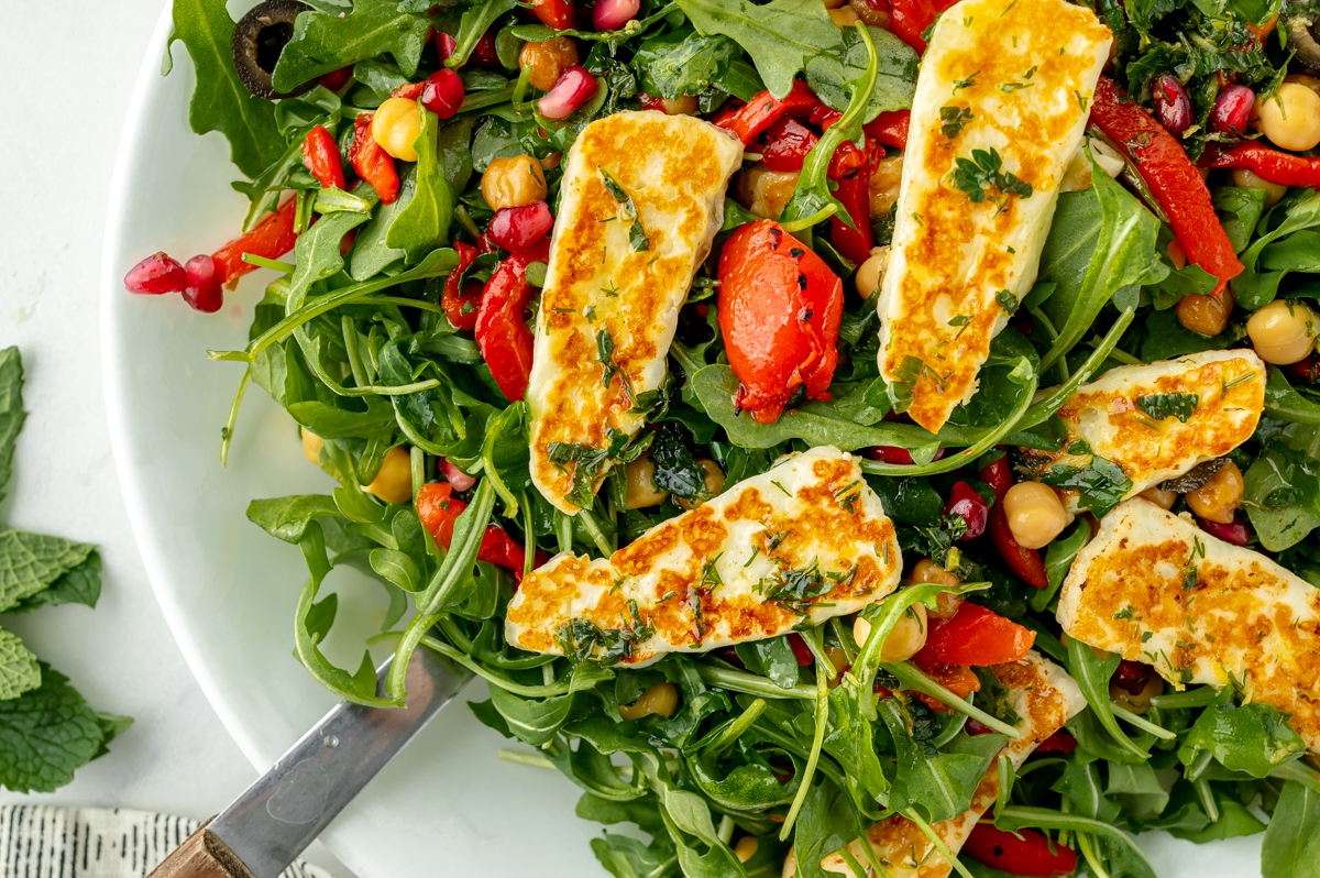 overhead shot of serving spoon in fried halloumi salad