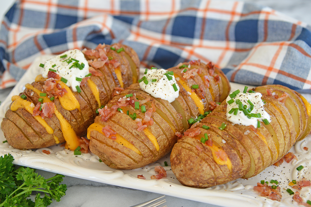 angled shot of three hasselback potatoes on platters