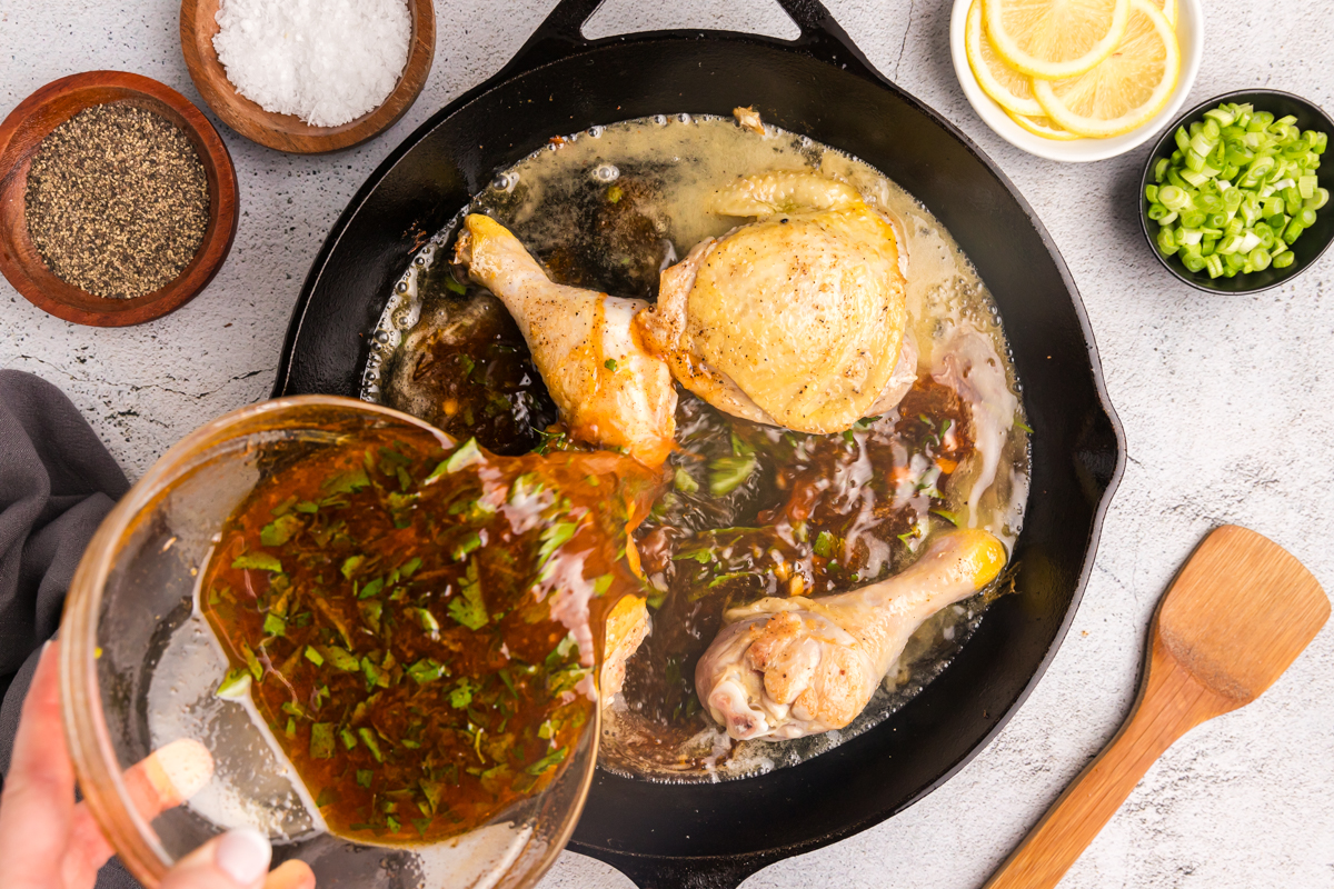 sauce pouring into skillet of chicken