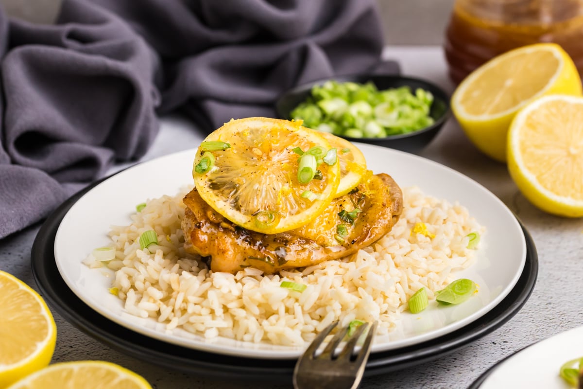 straight on shot of plate of rice topped with honey lemon garlic chicken