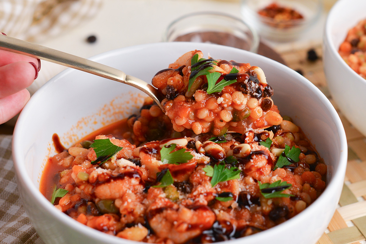 angled shot of spoon full of italian seafood stew