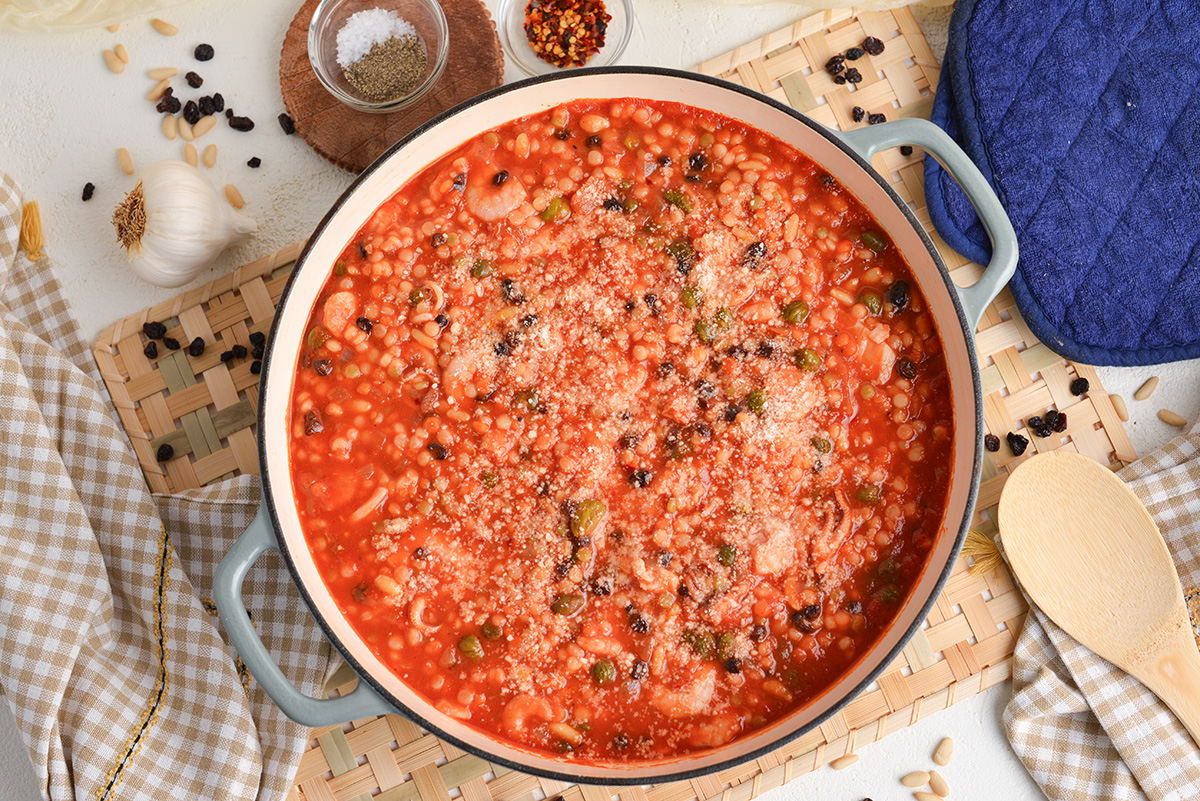 overhead shot of pot of cioppino topped with parmesan cheese