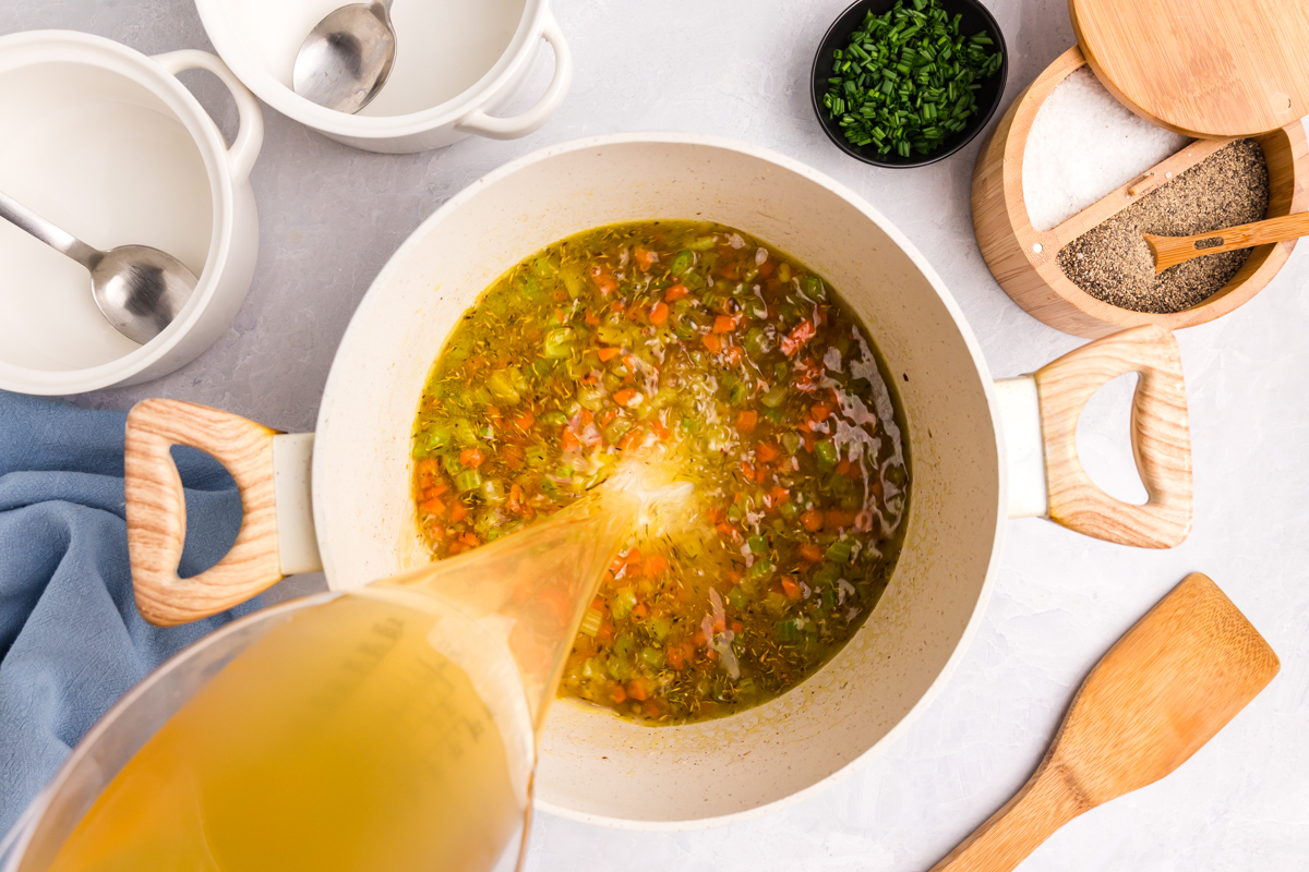 overhead shot of broth pouring into soup pot