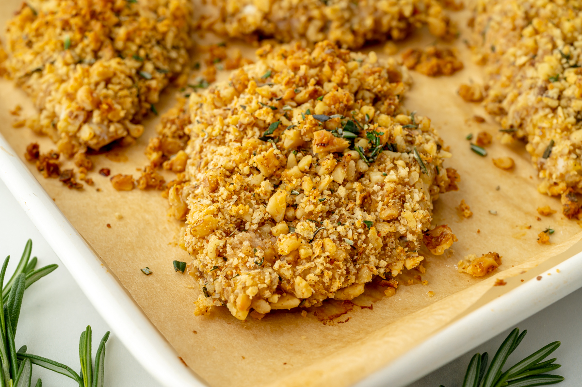 close up angled shot of breaded chicken on sheet pan