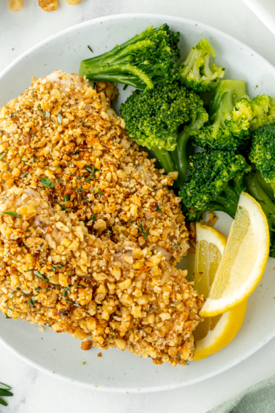 overhead shot of plate of walnut crusted chicken breasts with broccoli