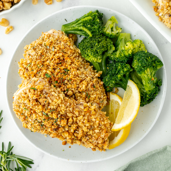 overhead shot of plate of walnut crusted chicken breasts with broccoli