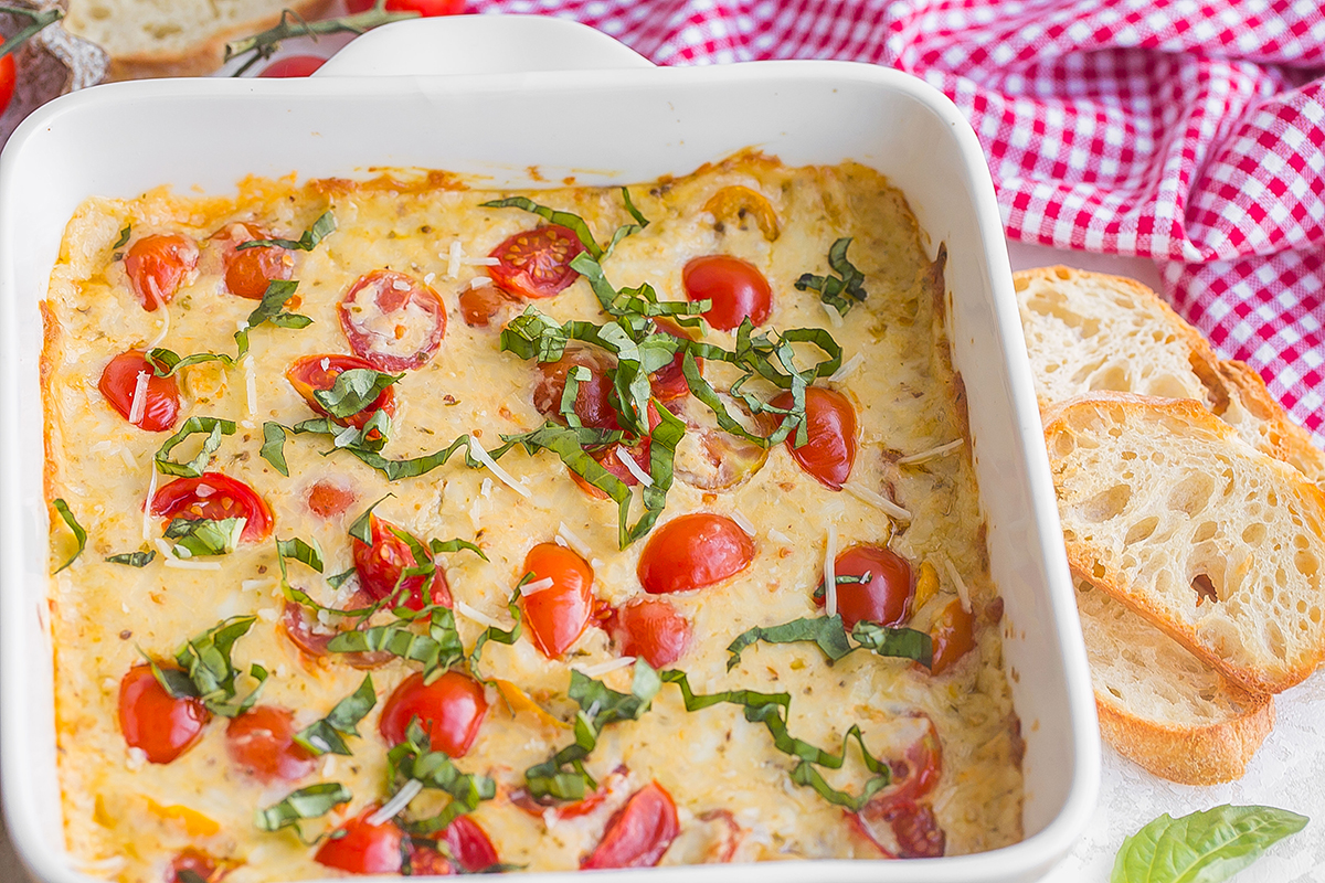 angled shot of hot caprese dip in baking dish