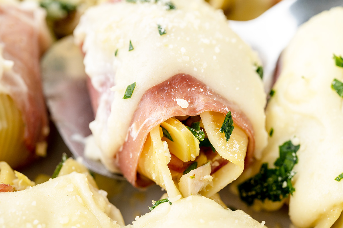 close up angled shot of chicken stuffed shell on serving spoon