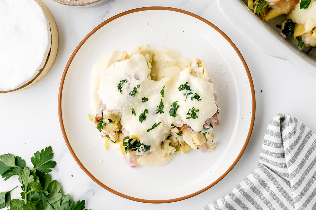 overhead shot of plate of chicken stuffed shells topped with brie sauce