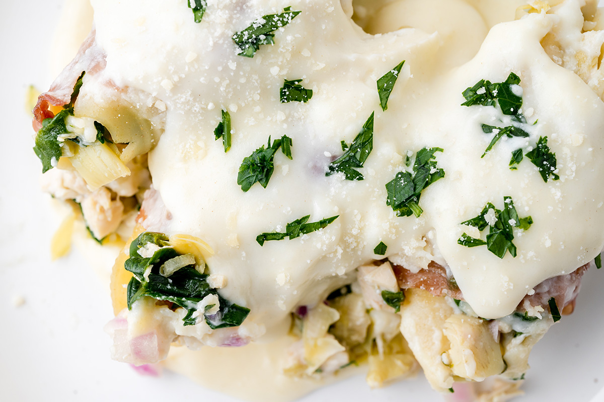 close up overhead shot of plate of chicken stuffed shells topped with brie sauce