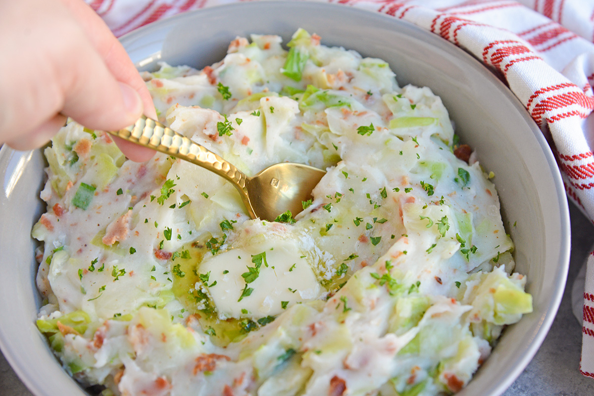 Spoon dipping into Irish Colcannon using cabbage