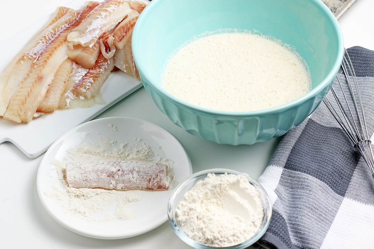 fish dredged in flour with bowl of batter next to it