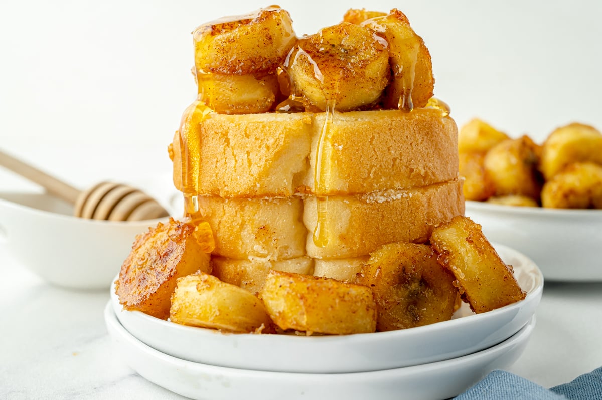 straight on shot of stack of pound cake topped with fried bananas and honey