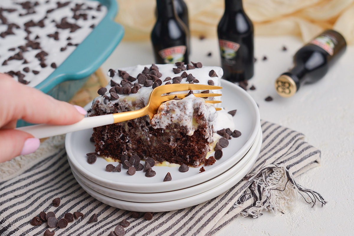 fork digging into slice of irish cream poke cake