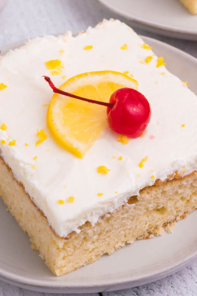 angled shot of slice of lemon sheet cake on plate