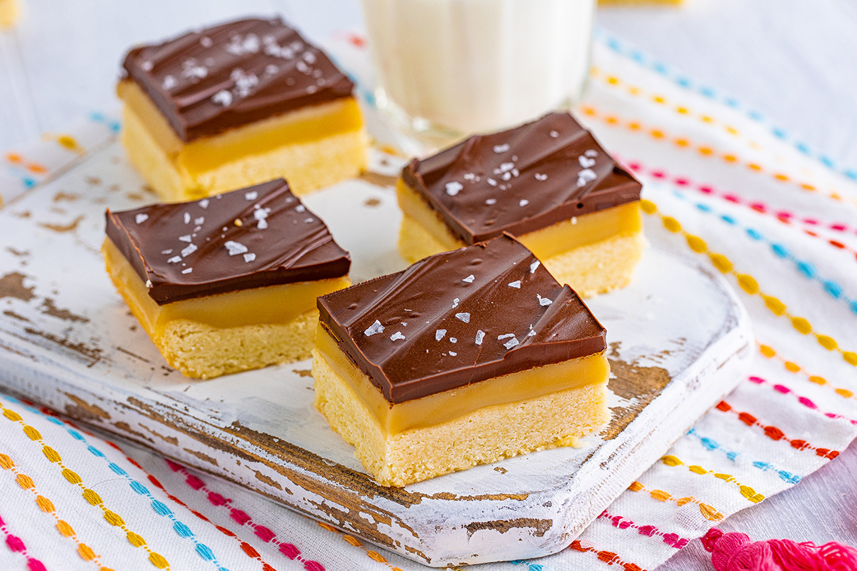 angled shot of millionaire shortbread bars on board