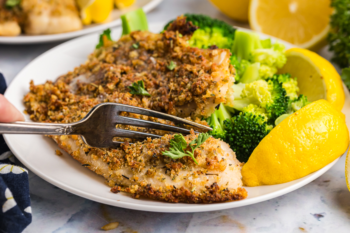 fork taking bite of breaded tilapia