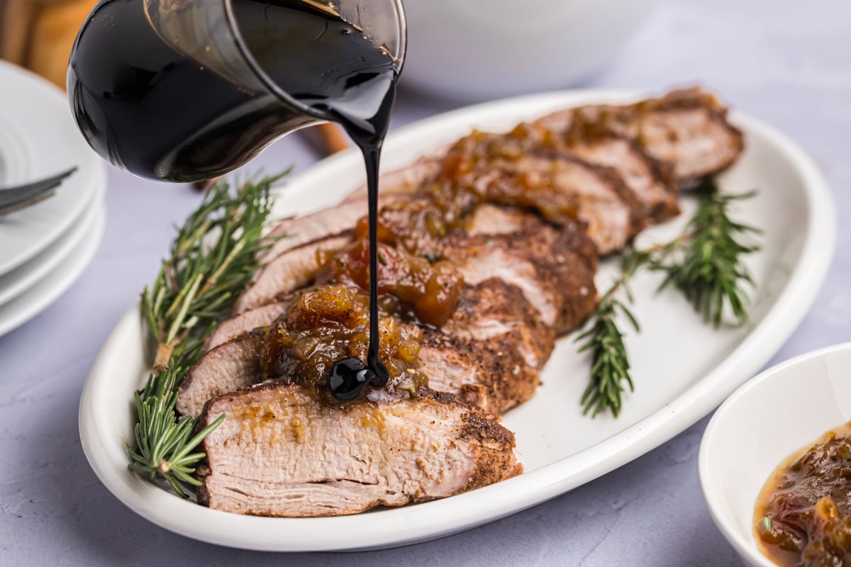 balsamic glaze poured over sliced pork tenderloin on serving dish