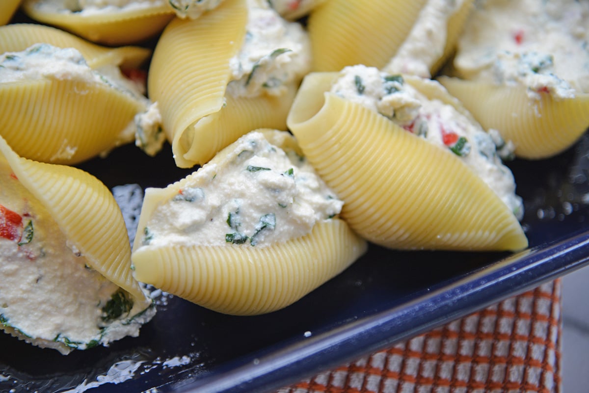 close up overhead shot of filled shells in blue baking dish