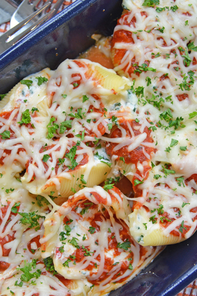 spinach stuffed shells in a blue casserole dish