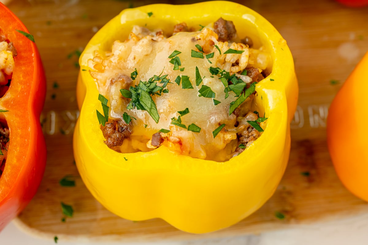 close up angled shot of yellow stuffed pepper on cutting board