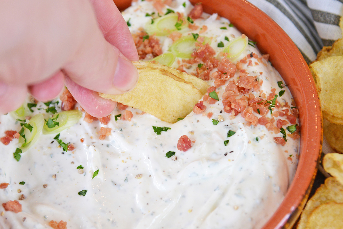 chip dipping into bowl of bacon ranch dip