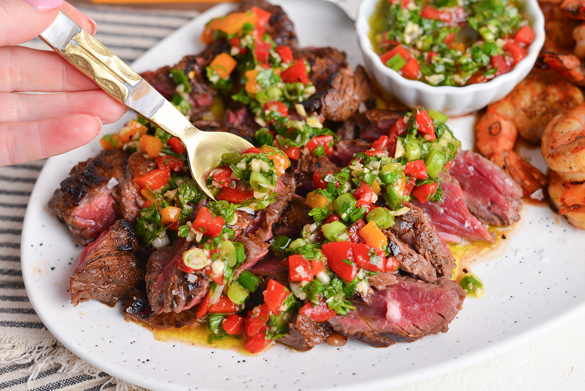 spoon adding bavette sauce to steak