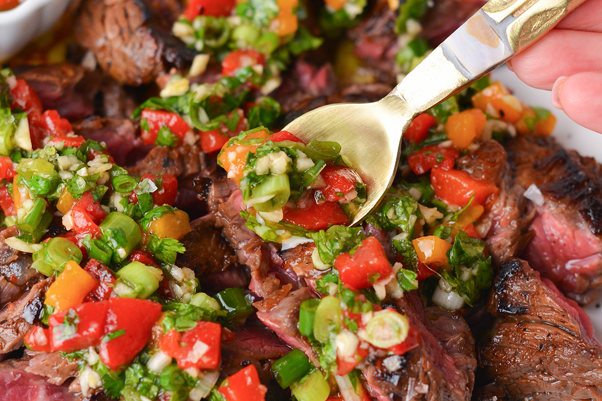 close up of spoon adding bavette sauce to steak