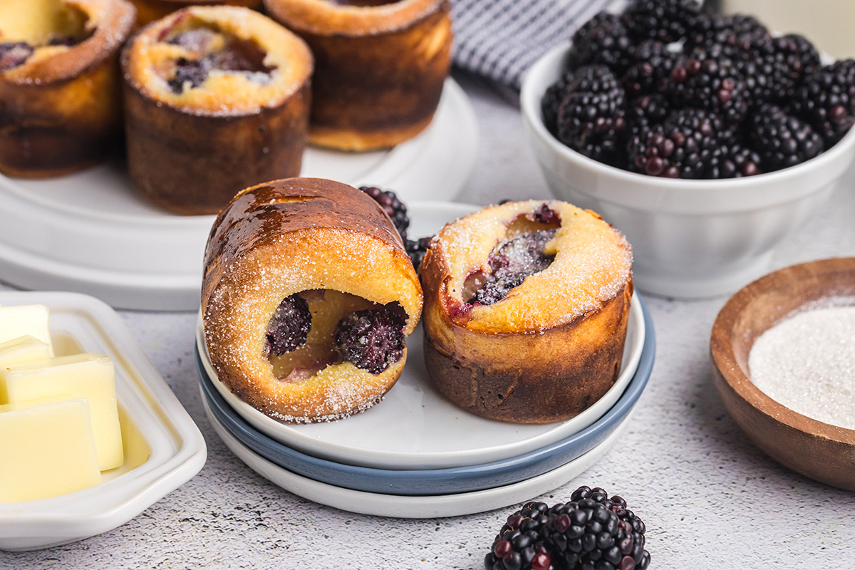 angled shot of two blackberry popovers on a plate