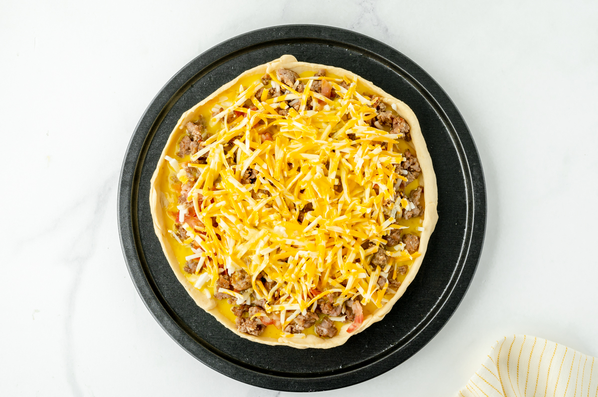 overhead shot of breakfast toppings on pizza crust