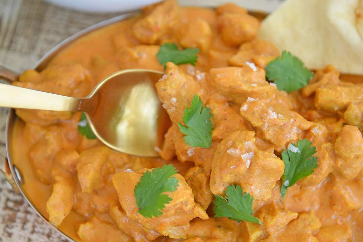 close up of spoon digging into butter chicken