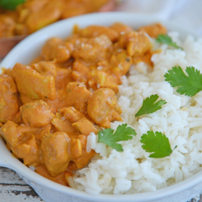 angled shot of bowl of butter chicken with rice