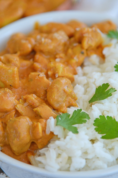 angled shot of bowl of butter chicken with rice