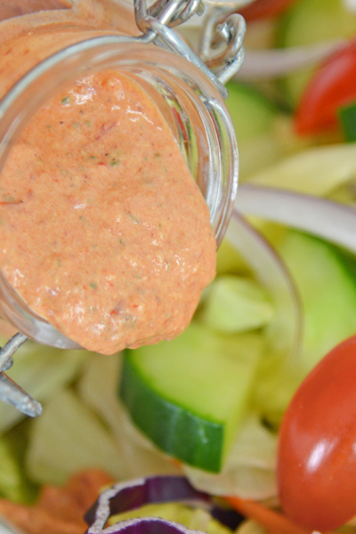 dressing pouring onto salad