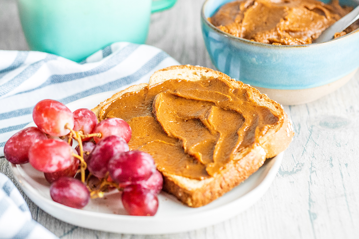 cookie butter spread on piece of bread with grapes