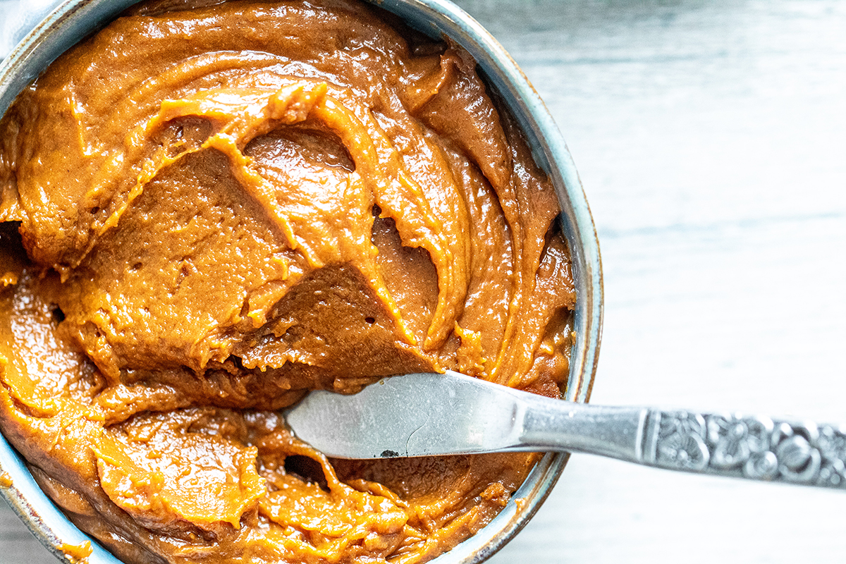 close up overhead shot of knife in bowl of cookie butter