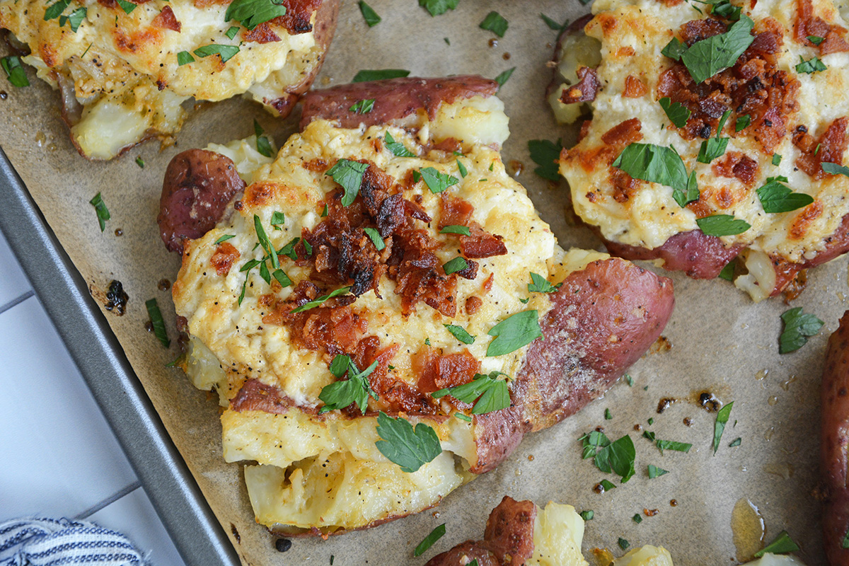 crab stuffed potatoes on a rimmed baking sheet