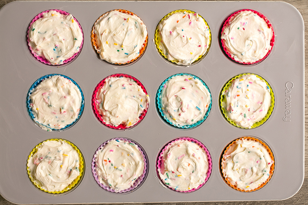 overhead shot of cheesecake batter added to muffin tin