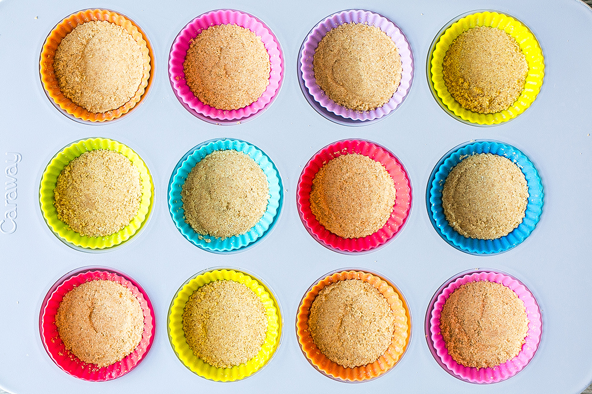 overhead shot of graham cracker crumbs in muffin tins