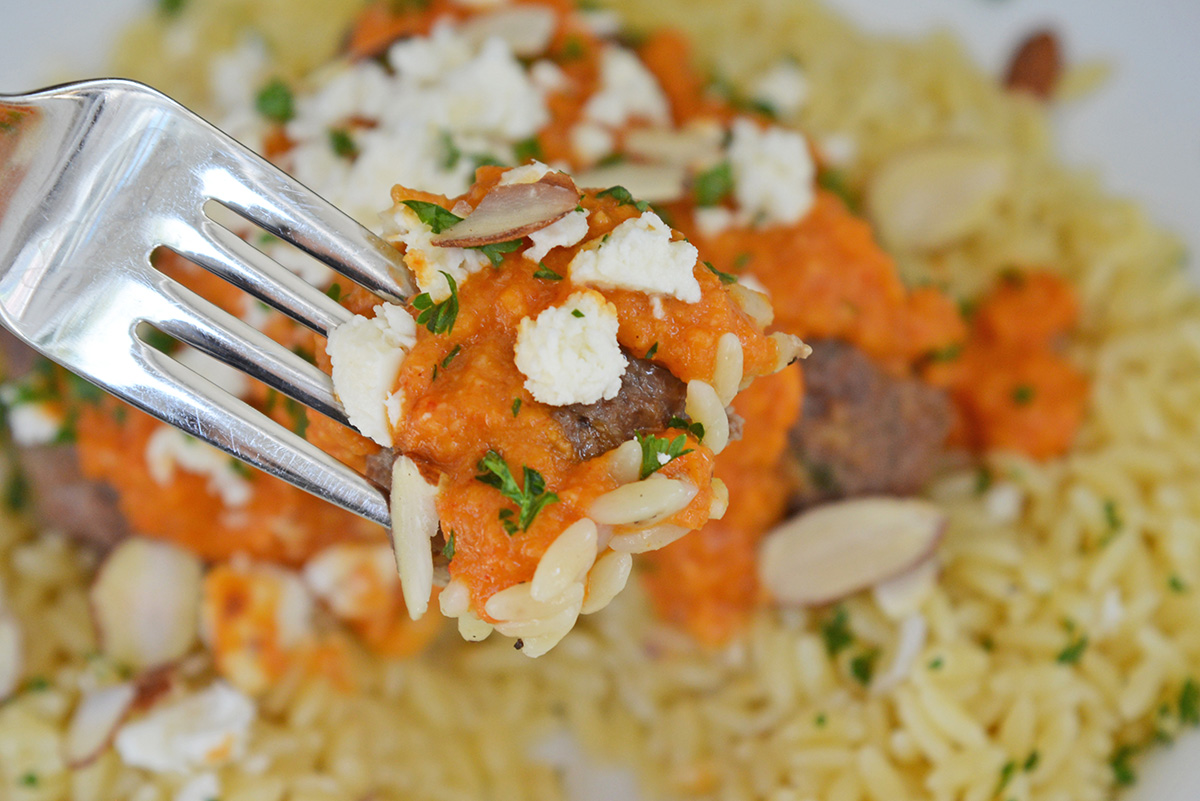 close up shot of bite of lamb meatball on fork